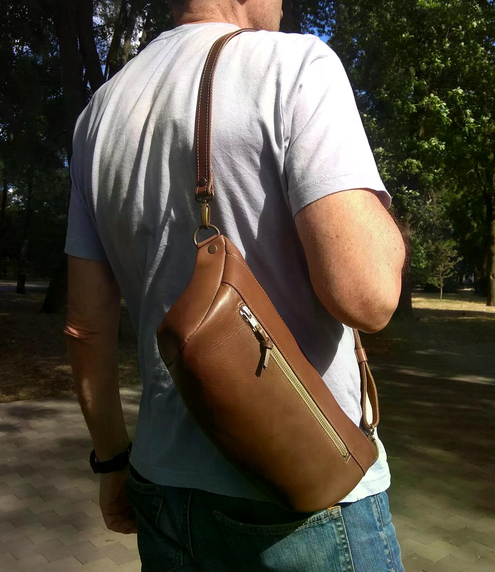 Handmade cognac brown leather sling bag worn across the back