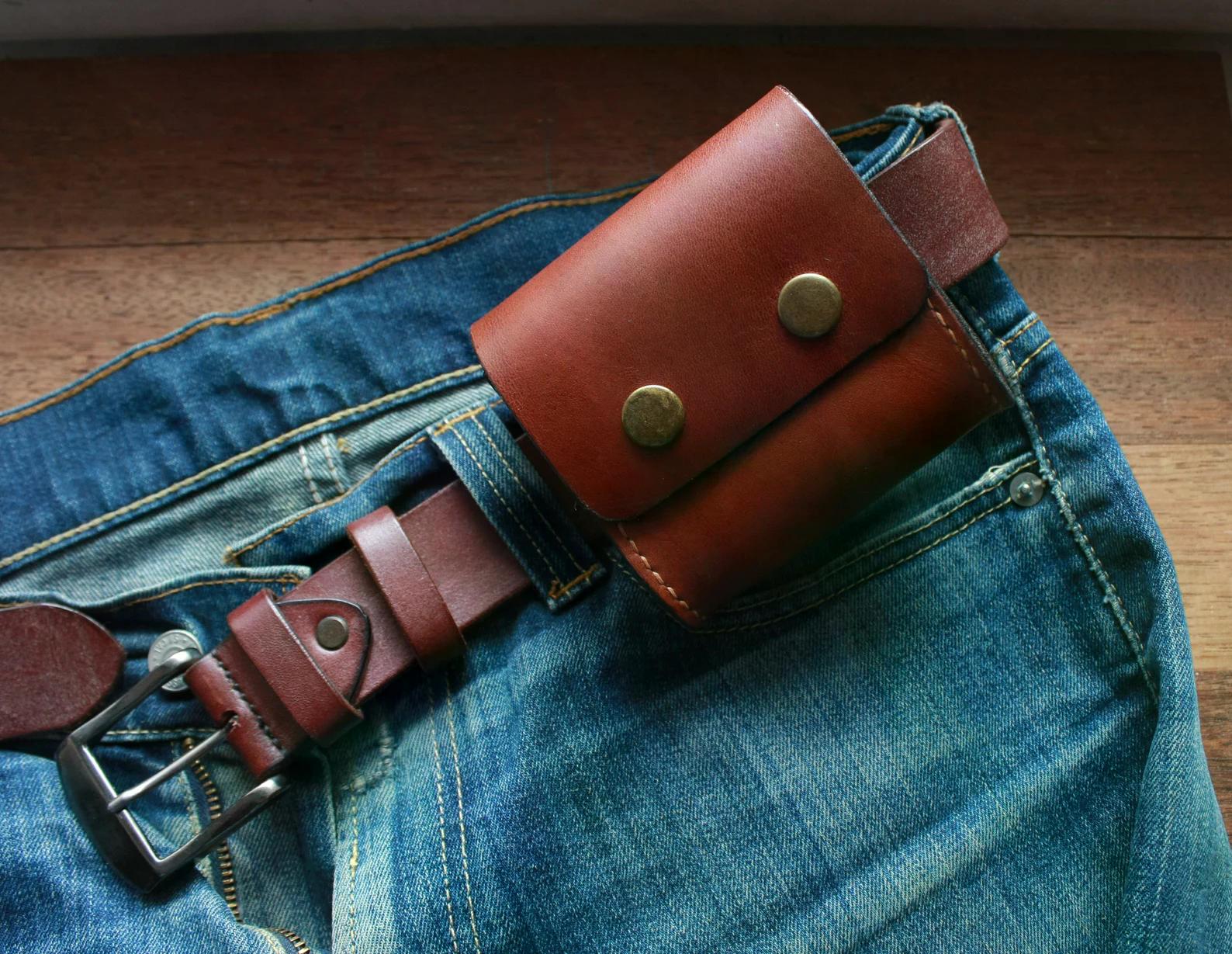 Handmade brown leather belt pouch with flap closure worn on denim jeans